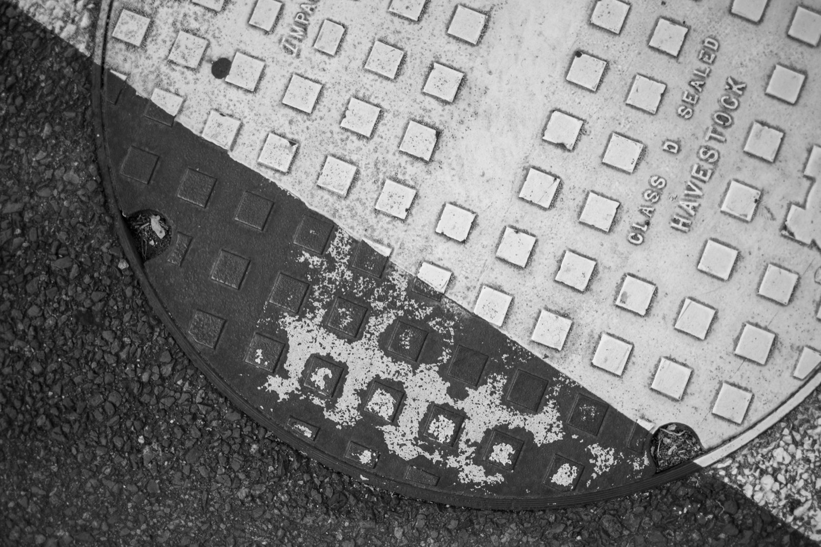 Plaque de regard d'égout dans une cour pavée, accès à la conduite d'évacuation avant un débouchage