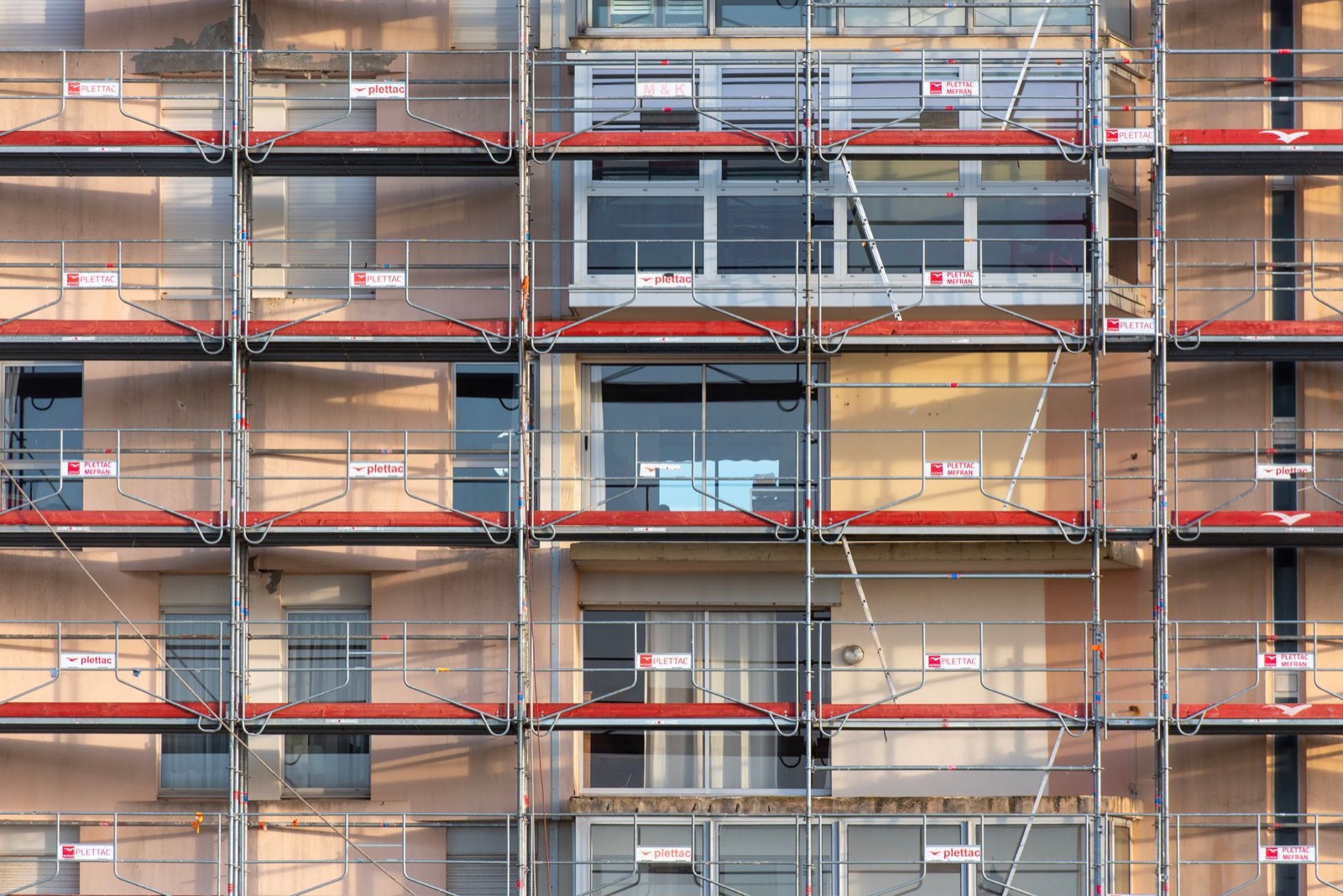 Ouvriers posant des panneaux d'isolation sur la façade extérieure d'une maison